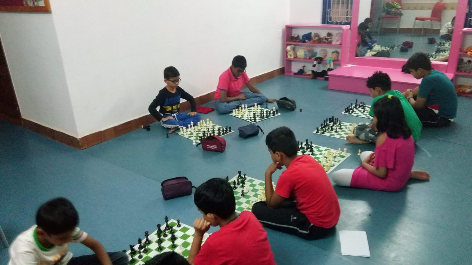 Group chess class in progress with students on chess boards